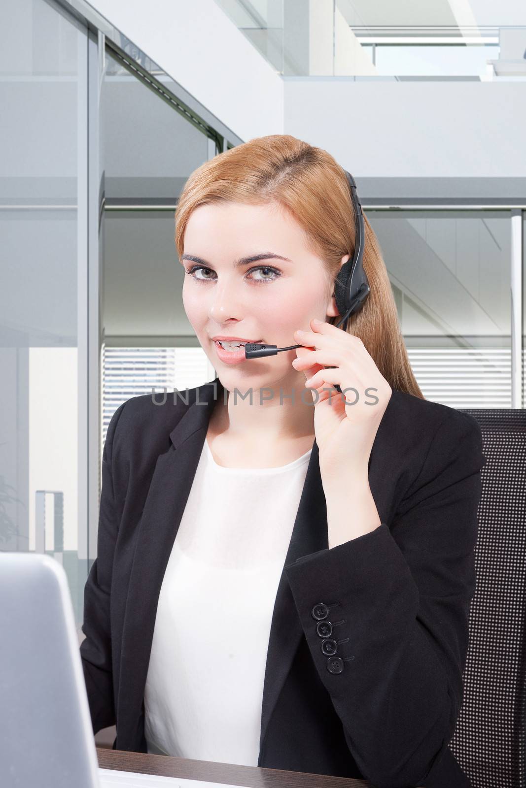 Businesswoman sit at desk and talking on headset 