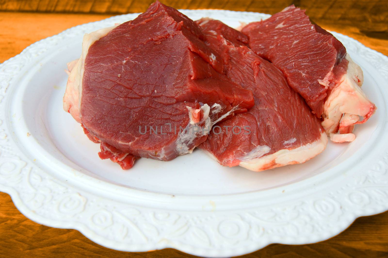 Damp meat on plate on white background