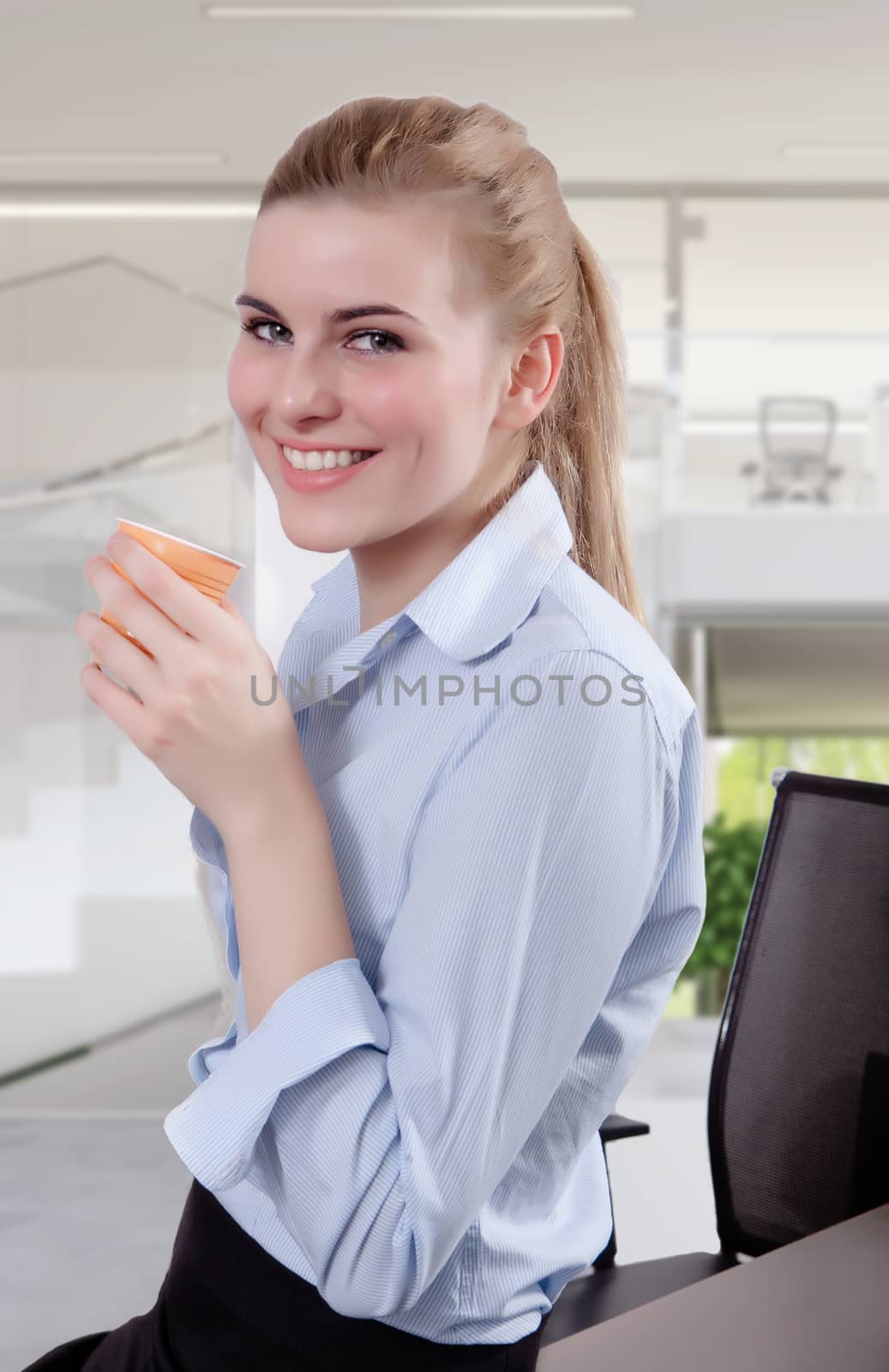 Beautiful Blond Young Businesswoman in Office with Coffee by matteobragaglio