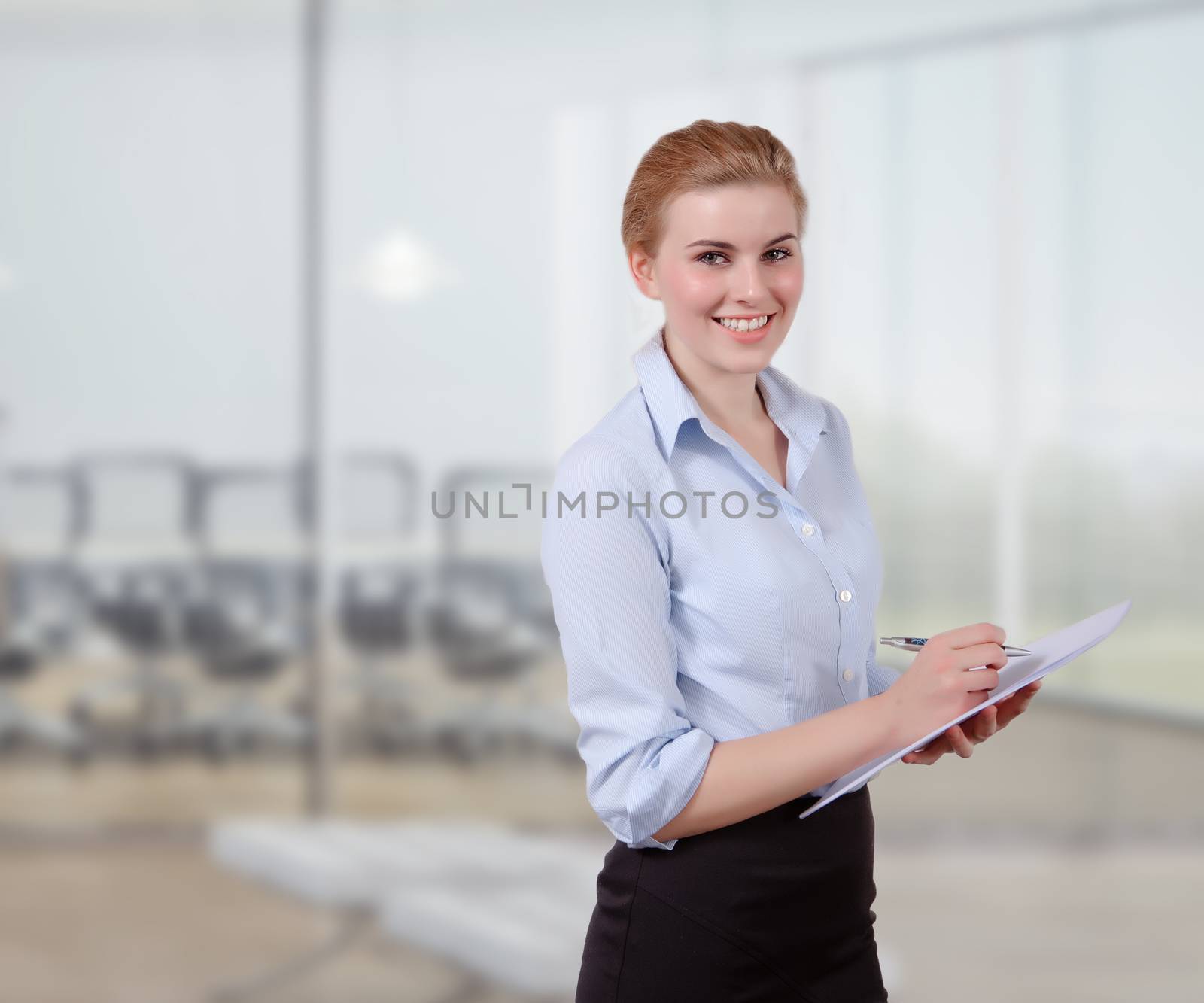 Young Businesswoman with Folio in her office