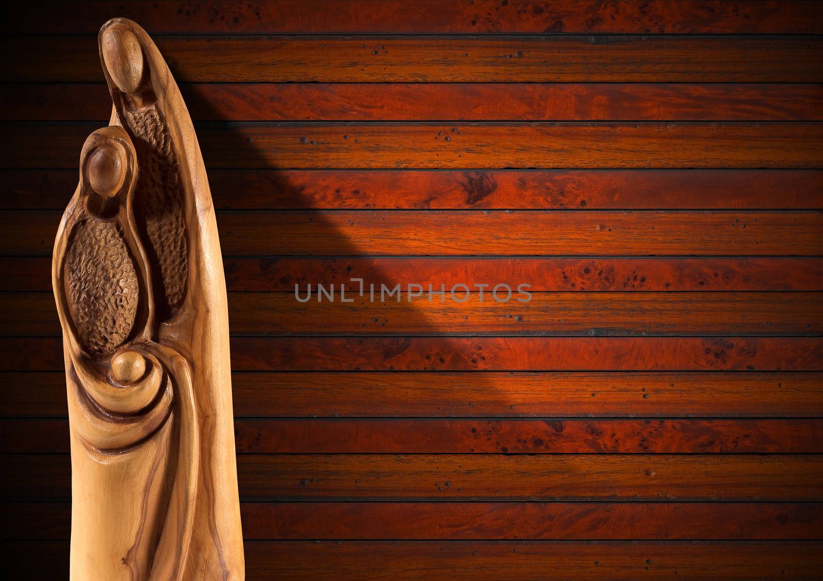 Wooden Christmas Crib with Mary, Joseph and baby Jesus on wooden background with shadows