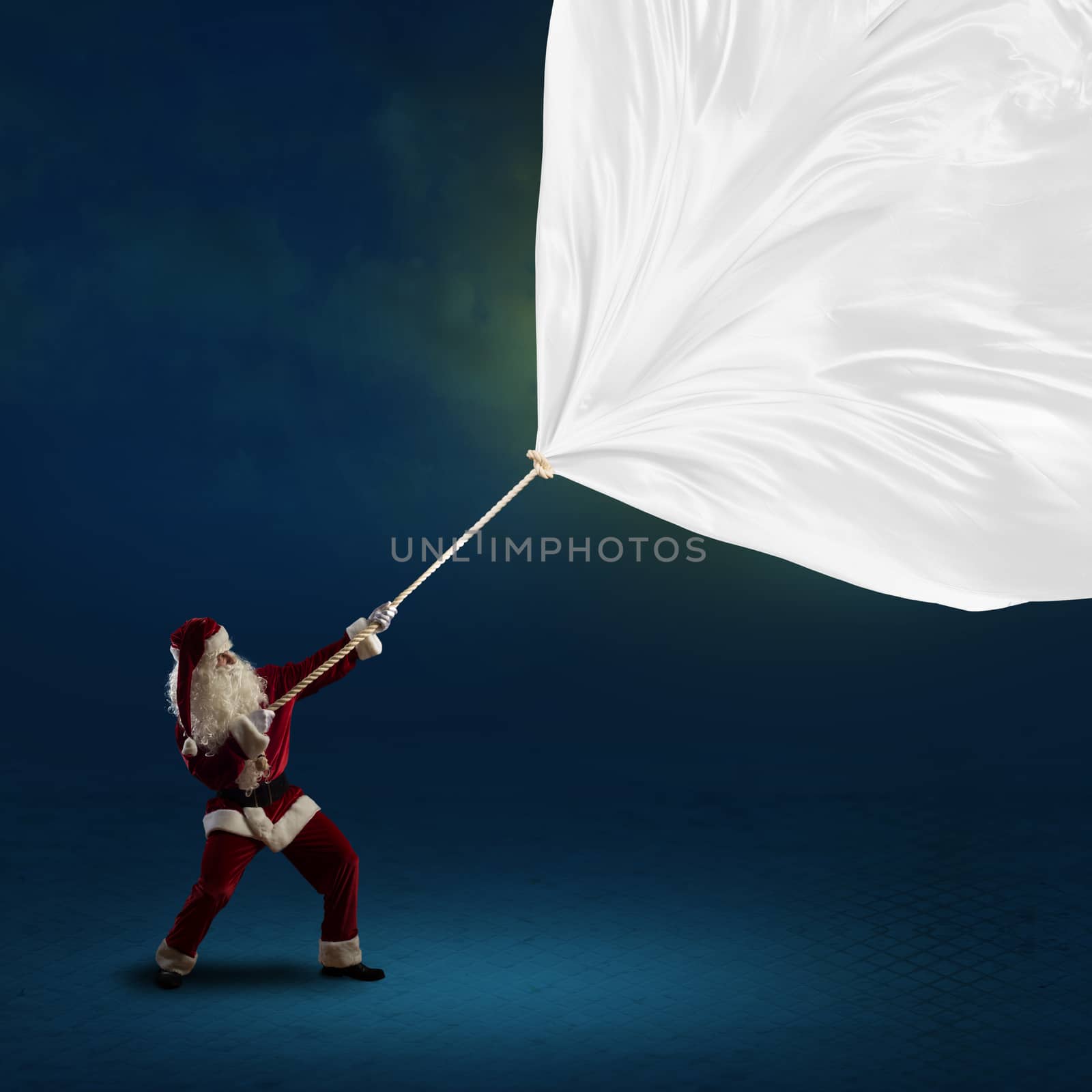 Santa Claus pulls a banner of cloth with a rope, place for text