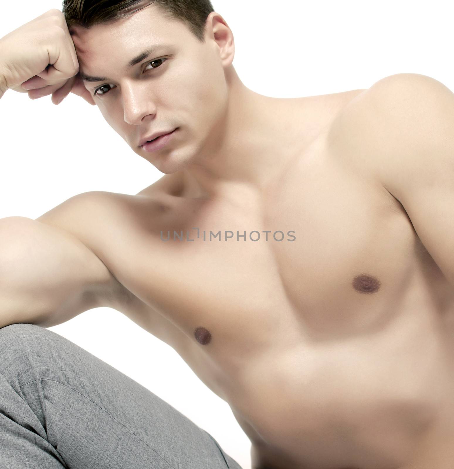 Close up of a muscular man posing on white background
