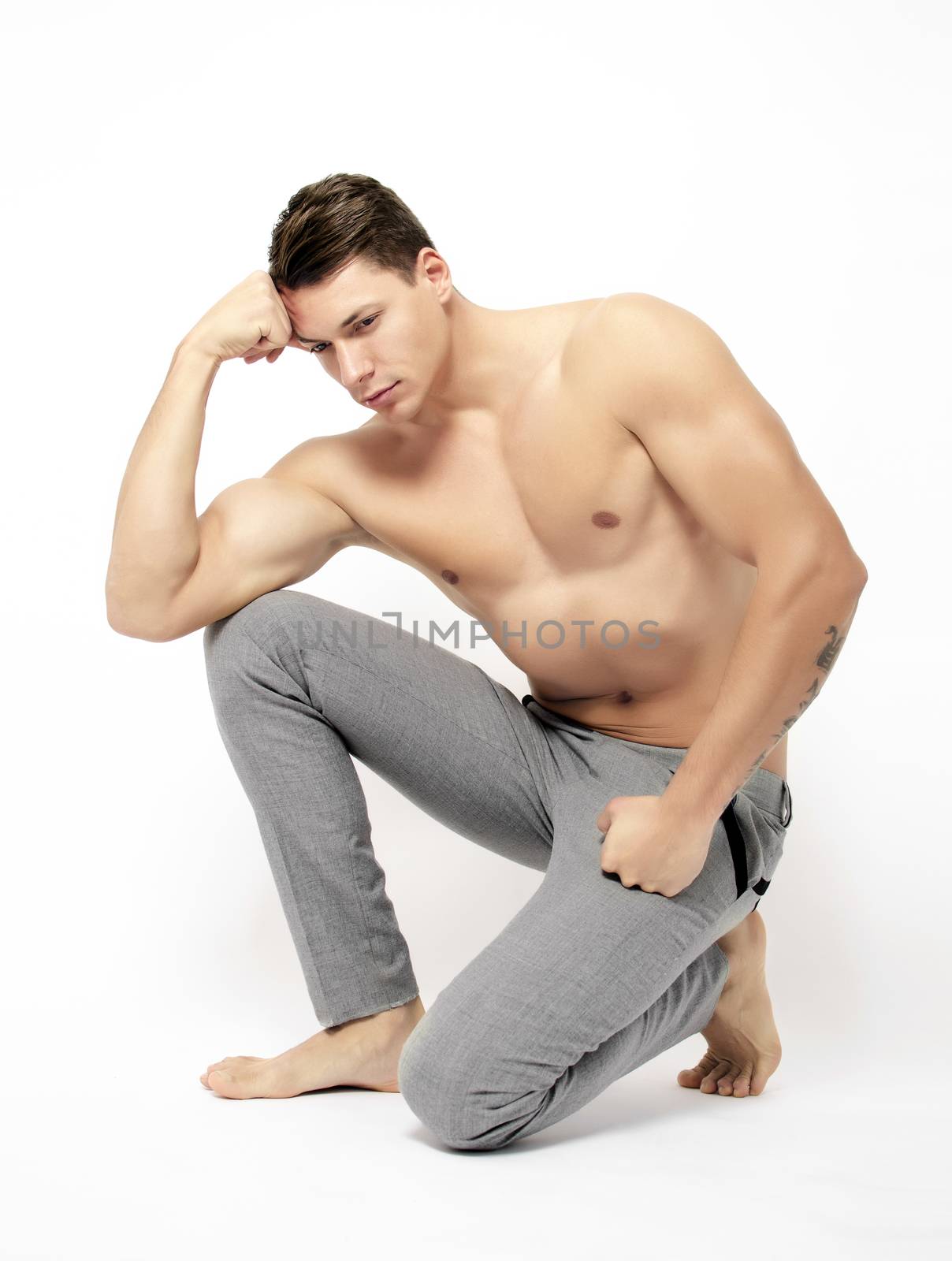 Beautiful muscular young man posing on white background