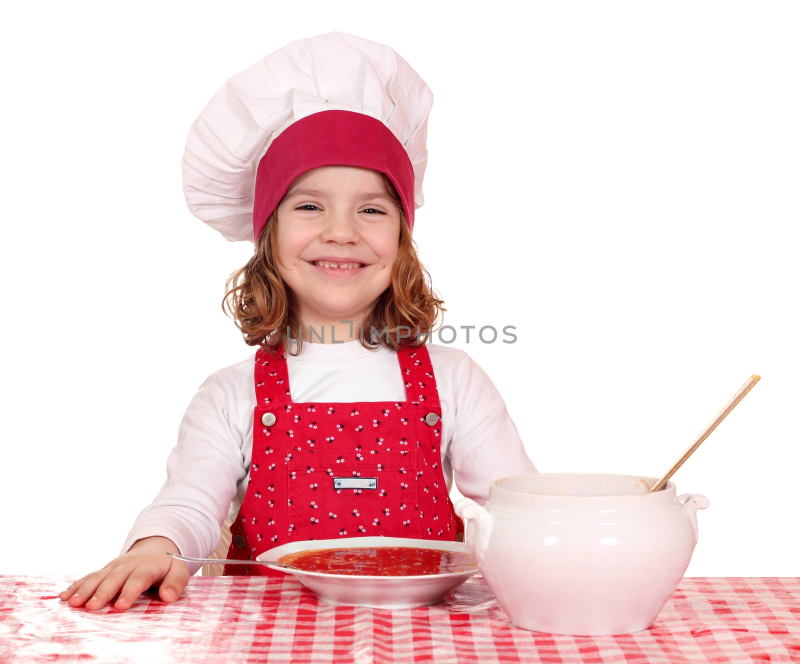 happy little girl cook with red tomato soup on table