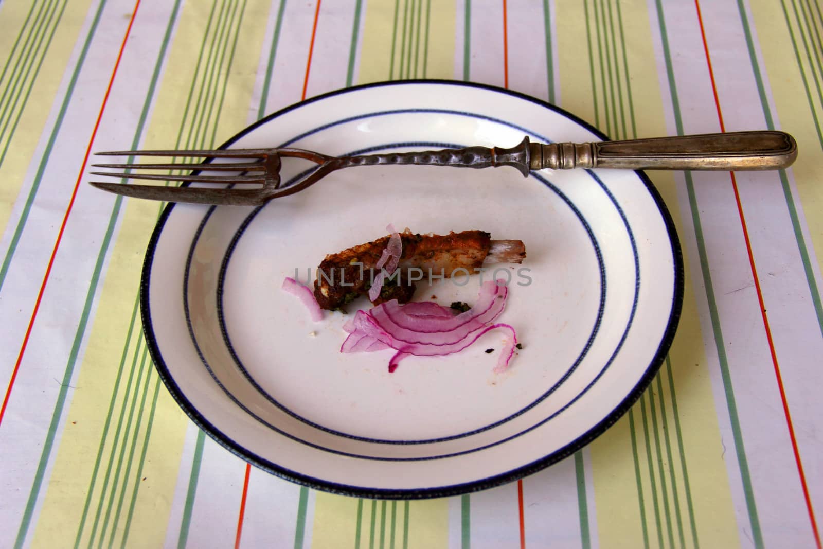 fork with knife on dish with  meat and onions