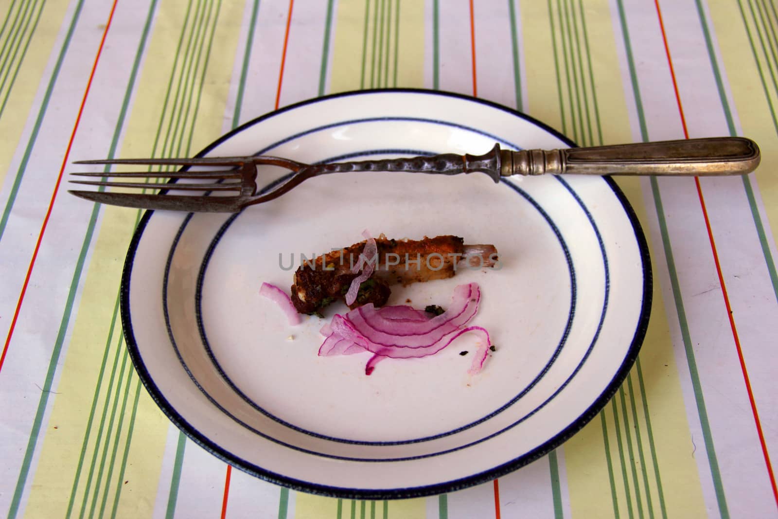 fork with knife on dish with  meat and onions