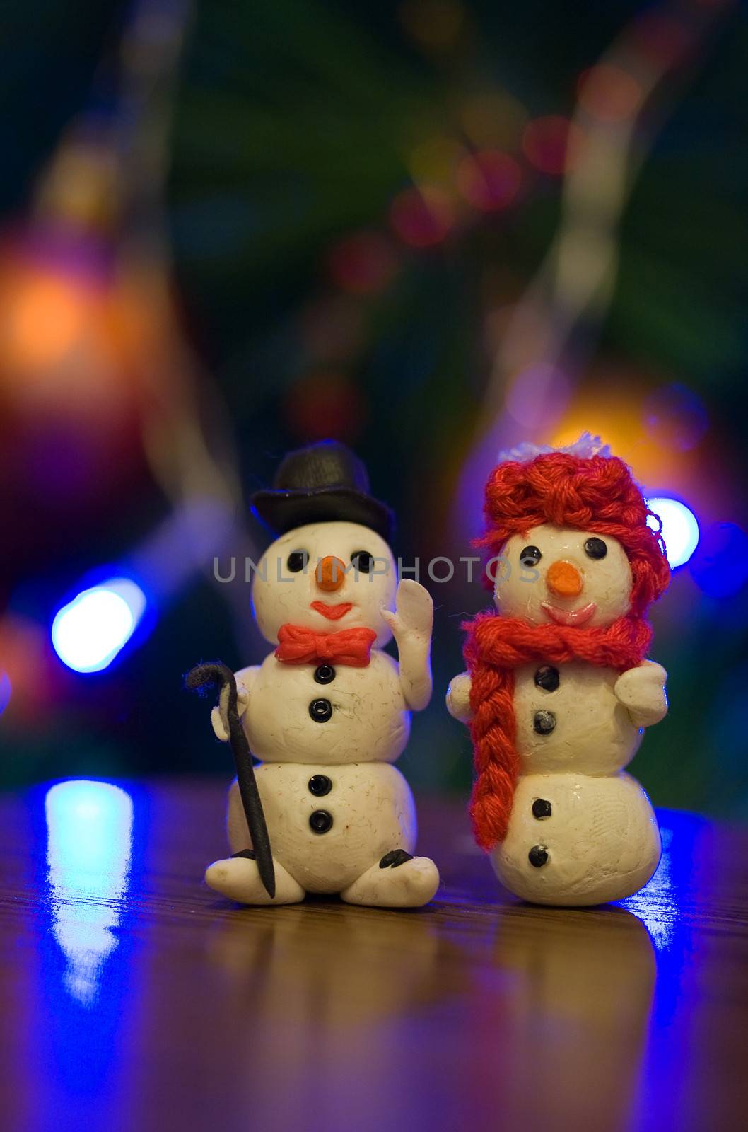 Two snowmen decoration by the Christmas tree 