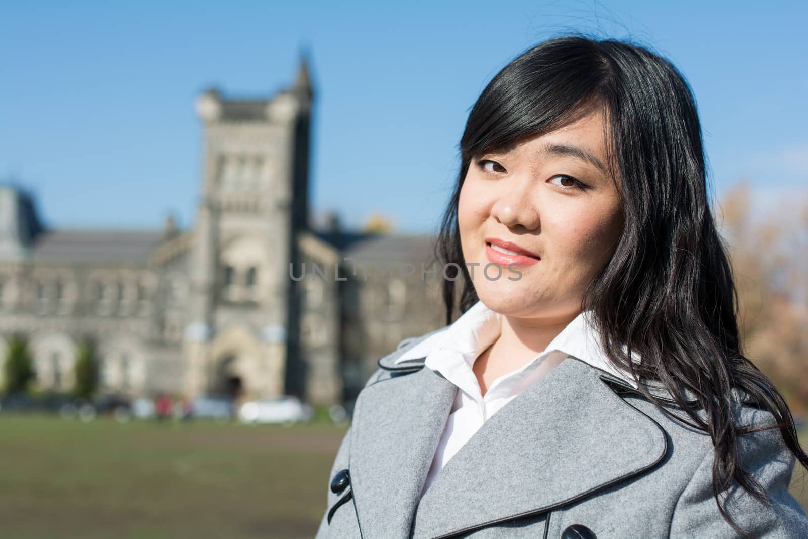 Outdoor portrait of young woman with old structure in the background