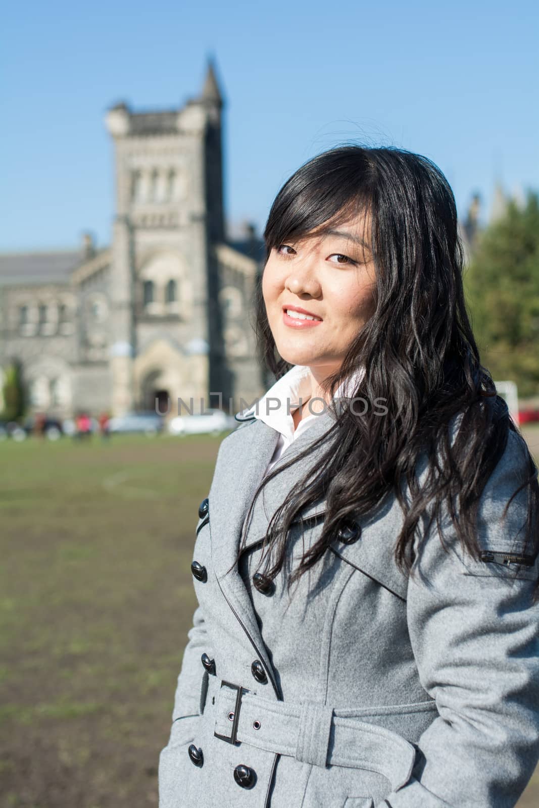 Outdoor portrait of young woman with old structure in the background