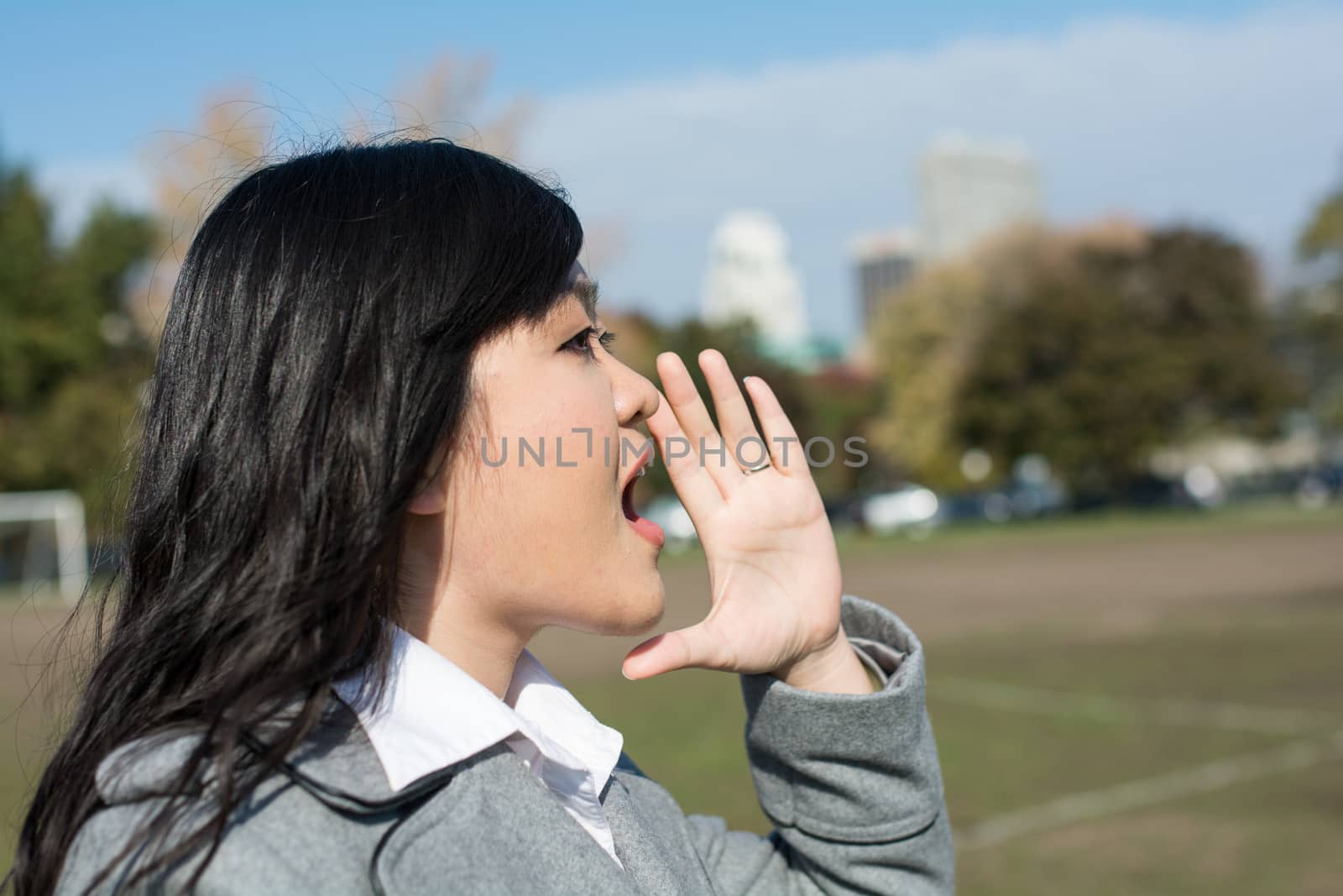 Outdoor portrait of young woman yelling at someone