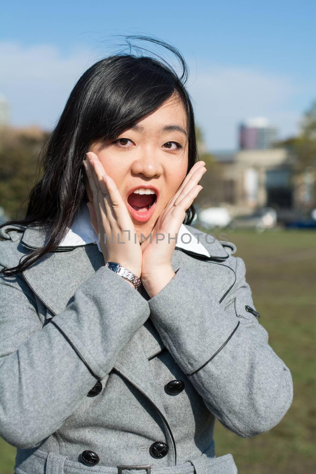 Outdoor portrait of young woman looking surprised