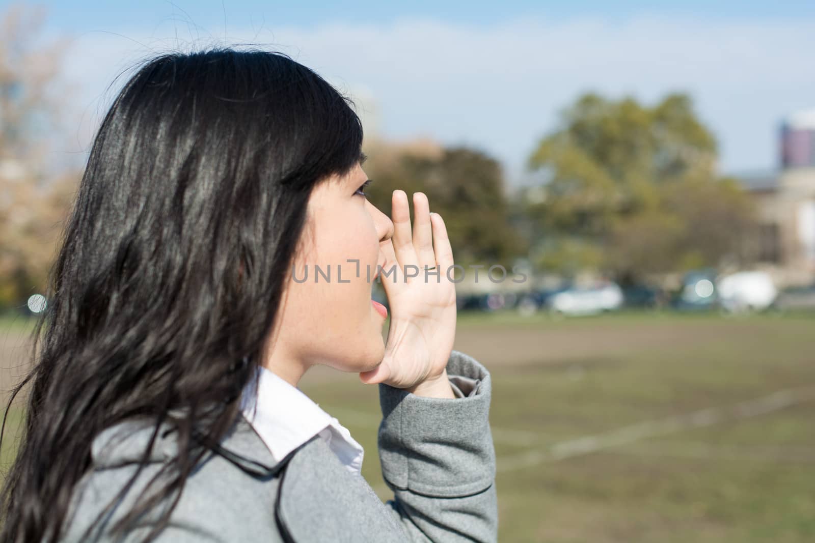 Outdoor portrait of young woman yelling at someone