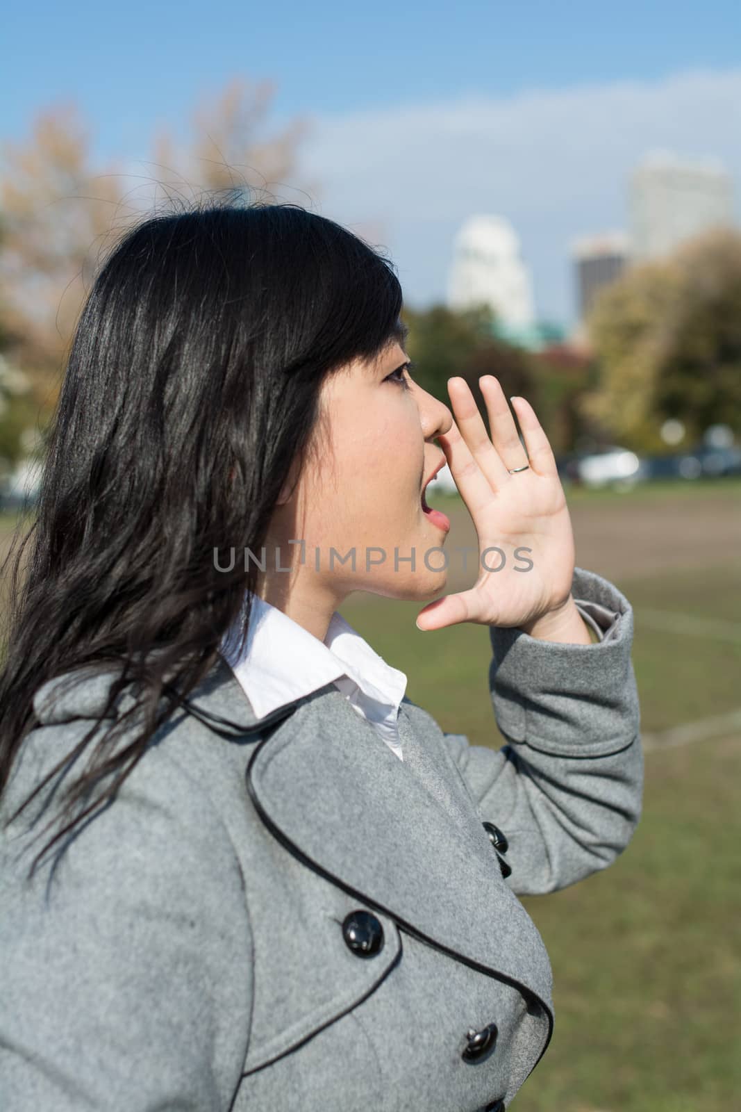 Outdoor portrait of young woman yelling at someone