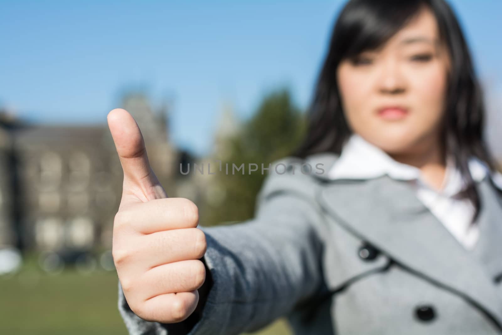 Young woman giving a thumb up during a sunny day