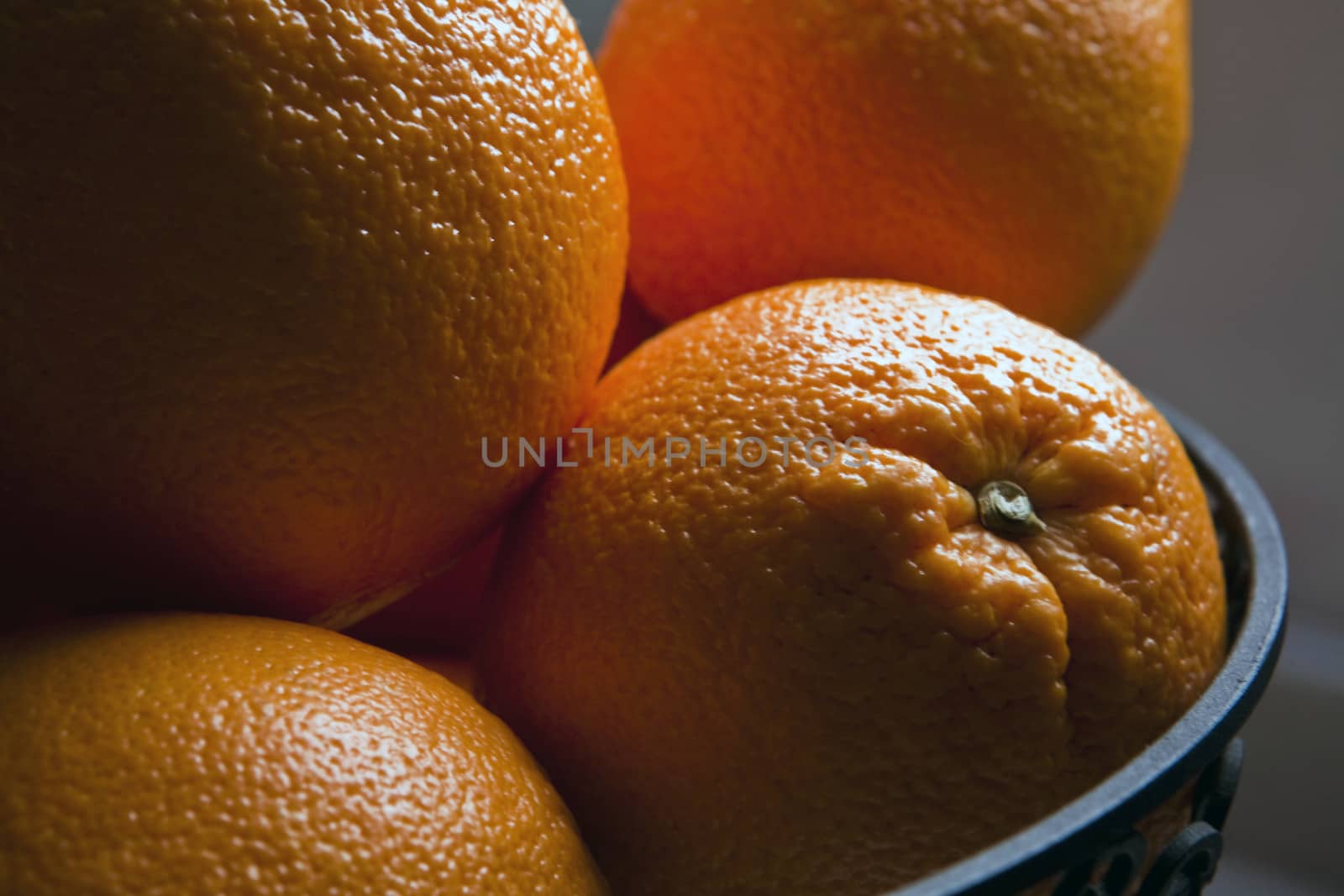 Some oranges in a bowl by digicomphoto