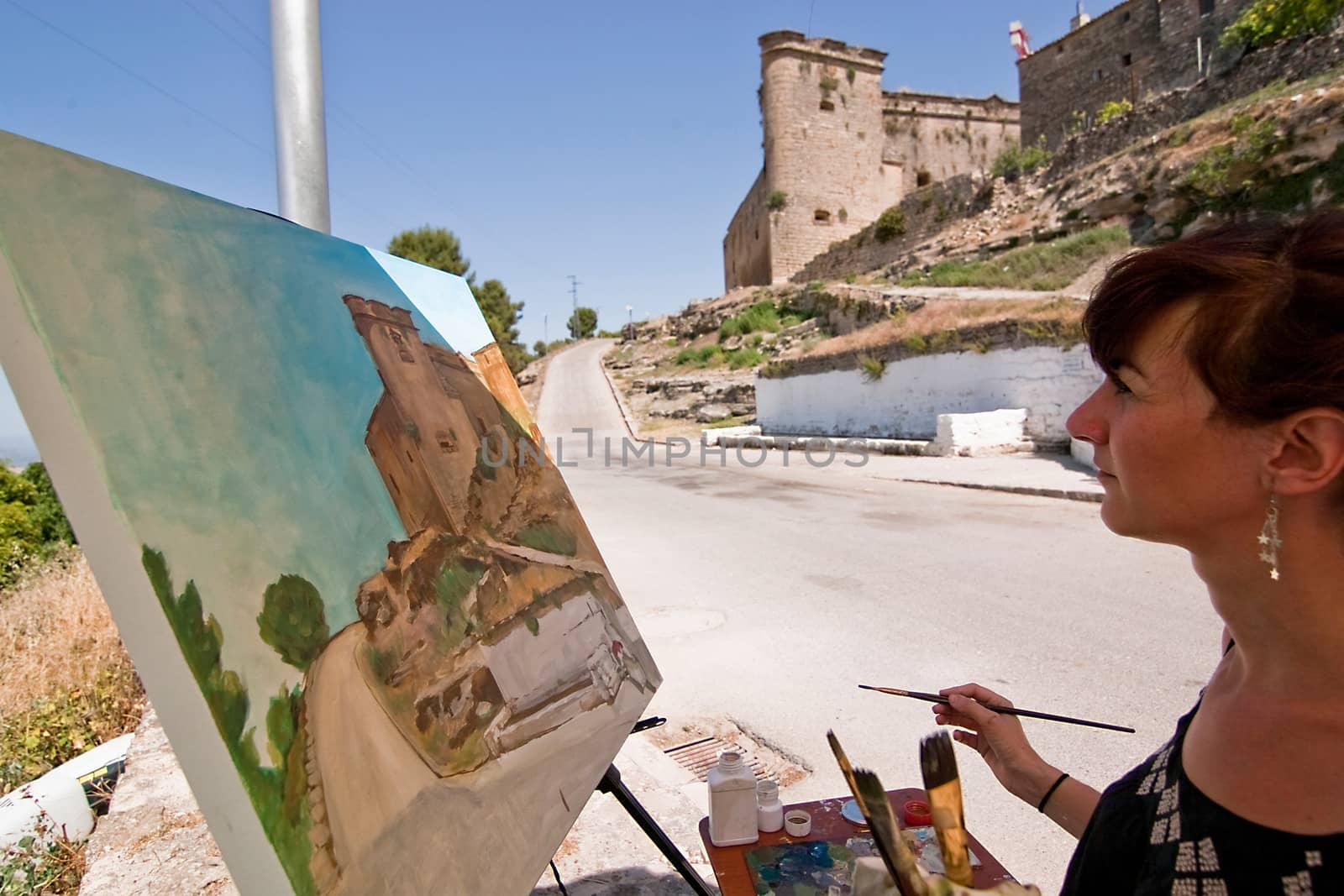 Painter paint a castle of Sabiote, Jaen province, Andalusia, Spain