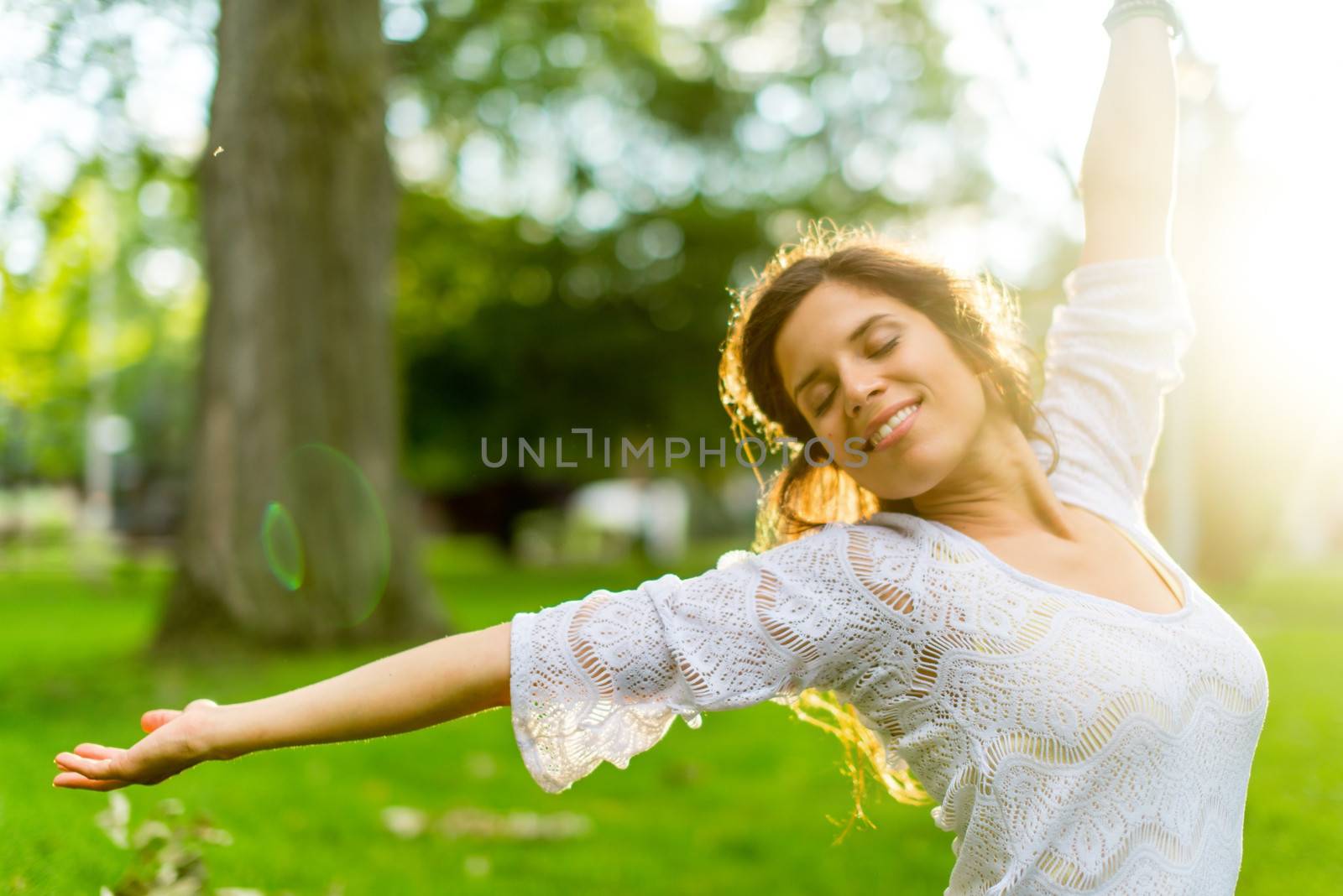 Beauty portrait of an attractive multi-ethnic girl enjoying warmth in a summer sunset. Sun Flare serie