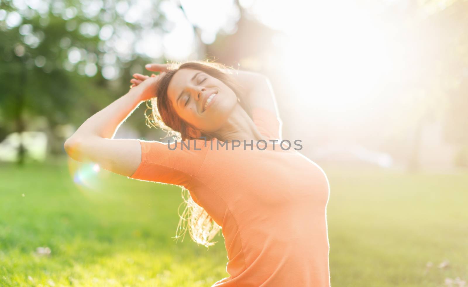 Beauty portrait of an attractive multi-ethnic girl enjoying the warmth of a summer sunset. Sun Flare serie