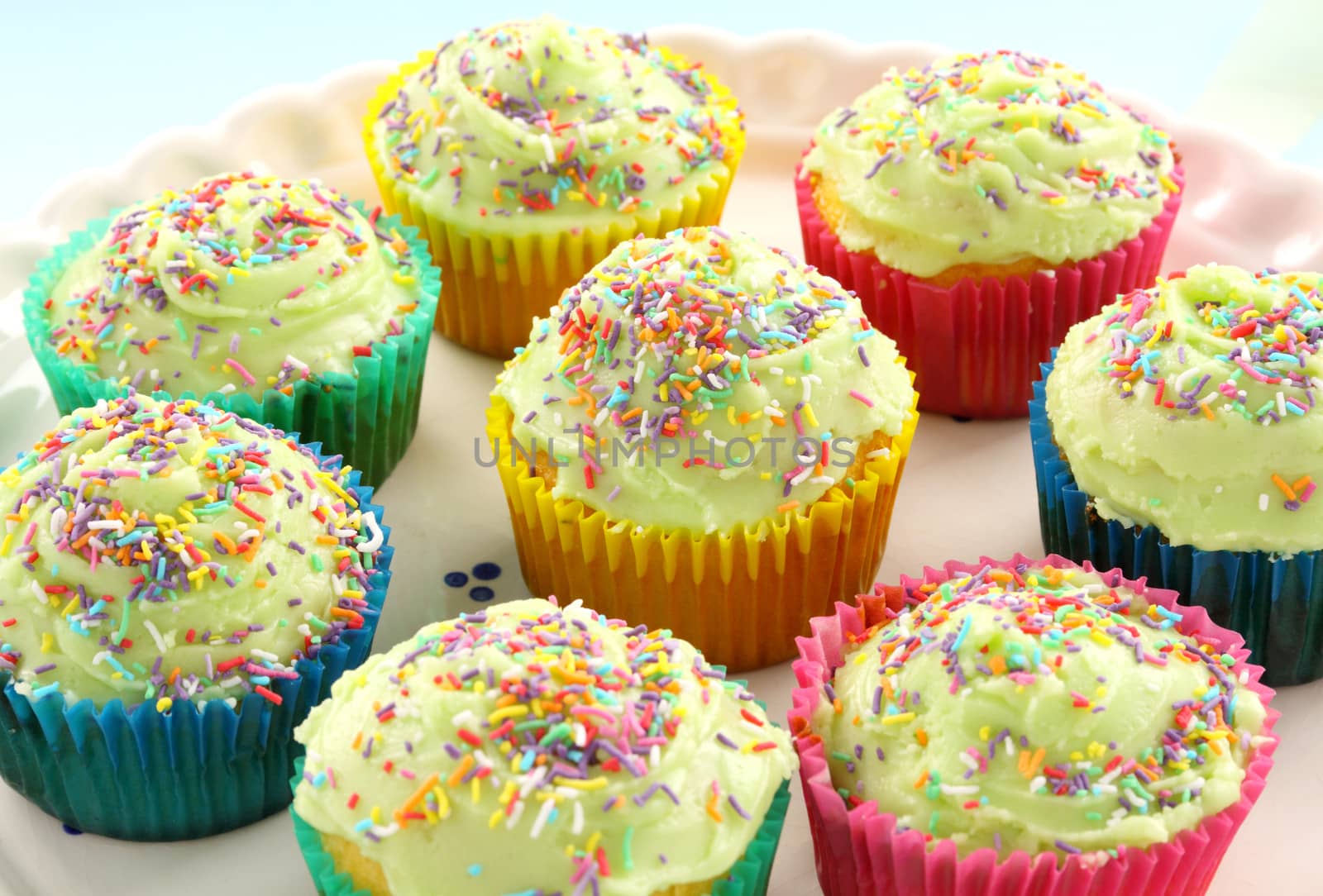 A plate of delicious iced cup cakes ready to serve.