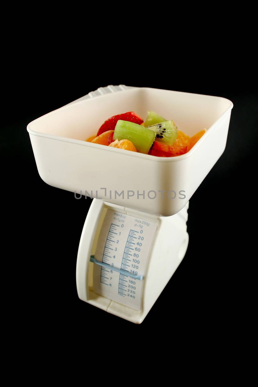 Set of kitchen scales weighing fresh fruit.