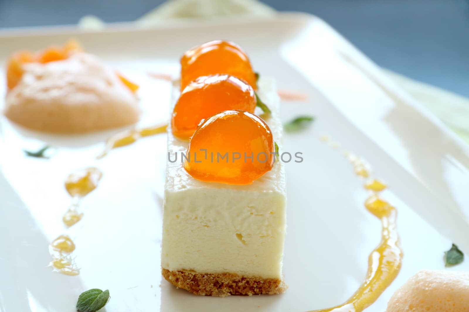 Delicious mandarin cheese cake with mandarin balls and a fruit sauce.