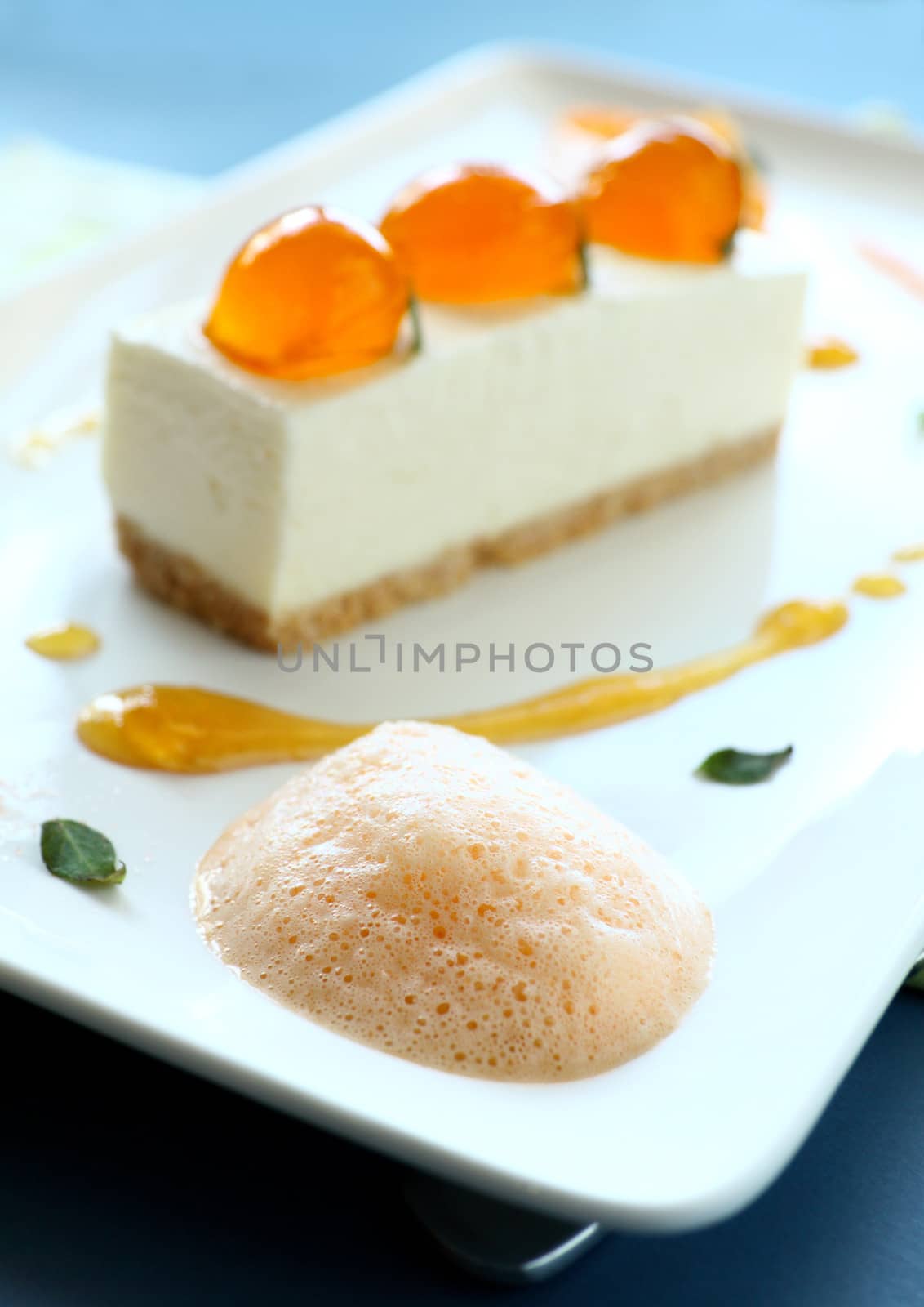 Delicious mandarin cheese cake with mandarin balls and orange foam.