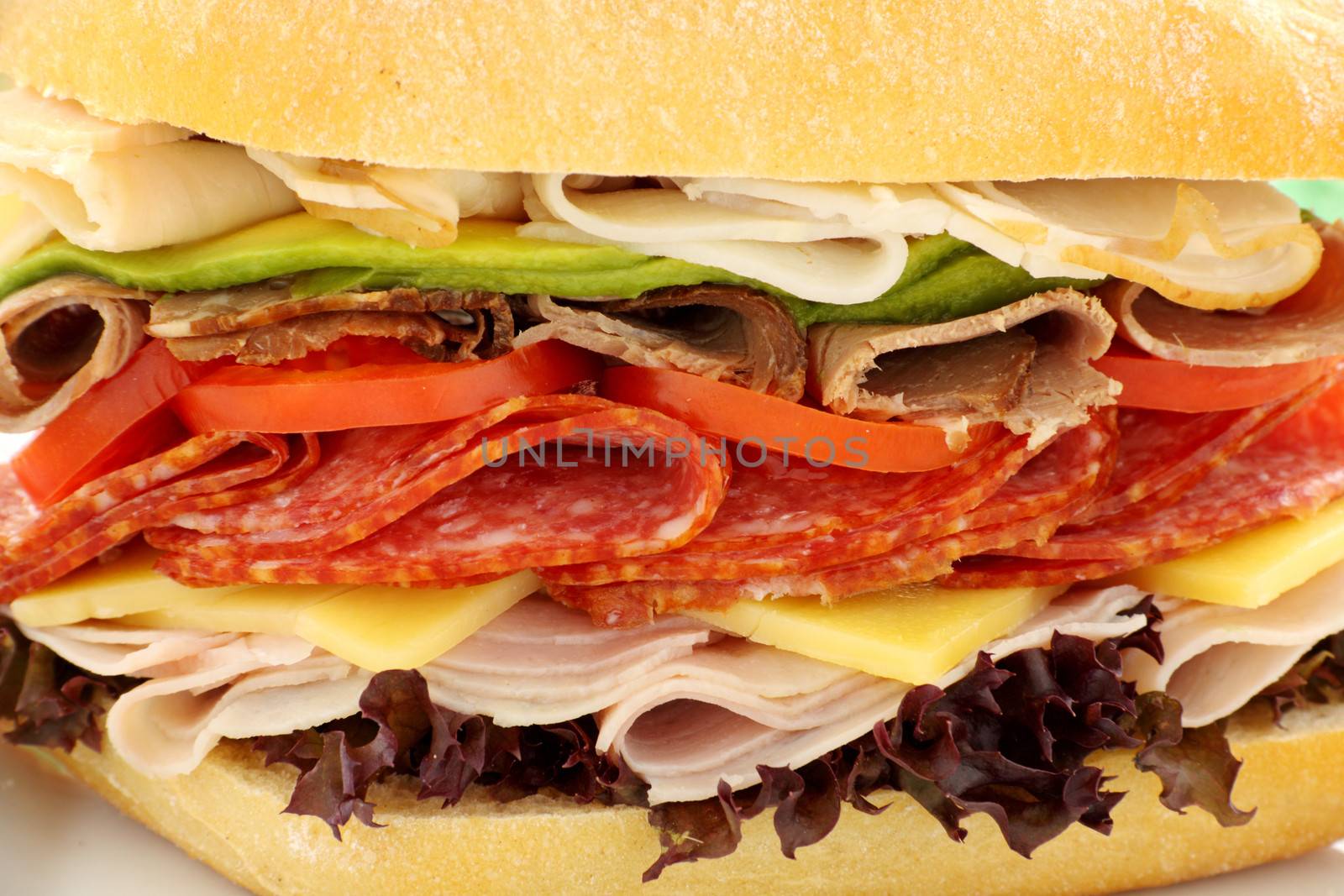 Mega meat roll consisting of ham, salami, roast beef and turkey with cheddar cheese and salad.