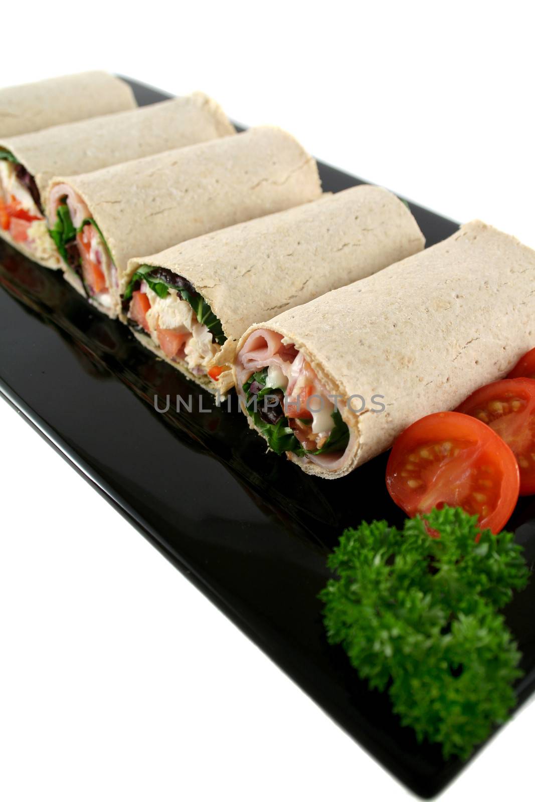 Mixed platter of delicious ham and chicken salad wraps.