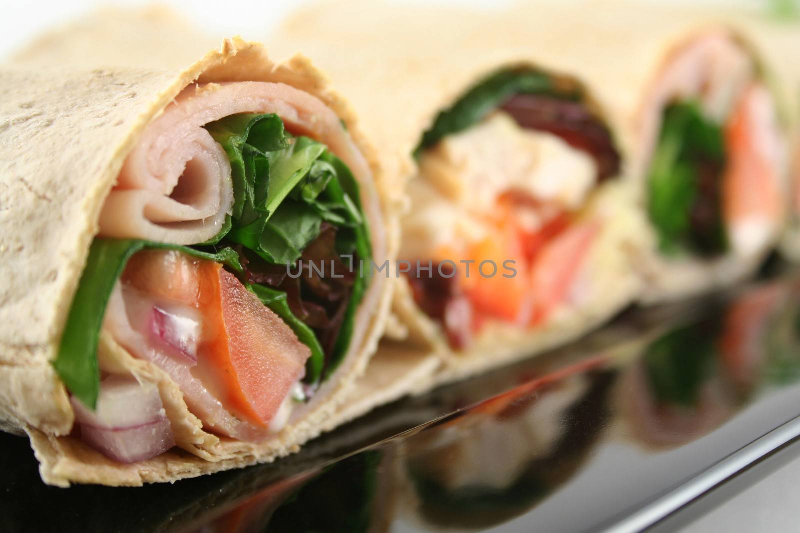 Mixed platter of delicious ham and chicken salad wraps.