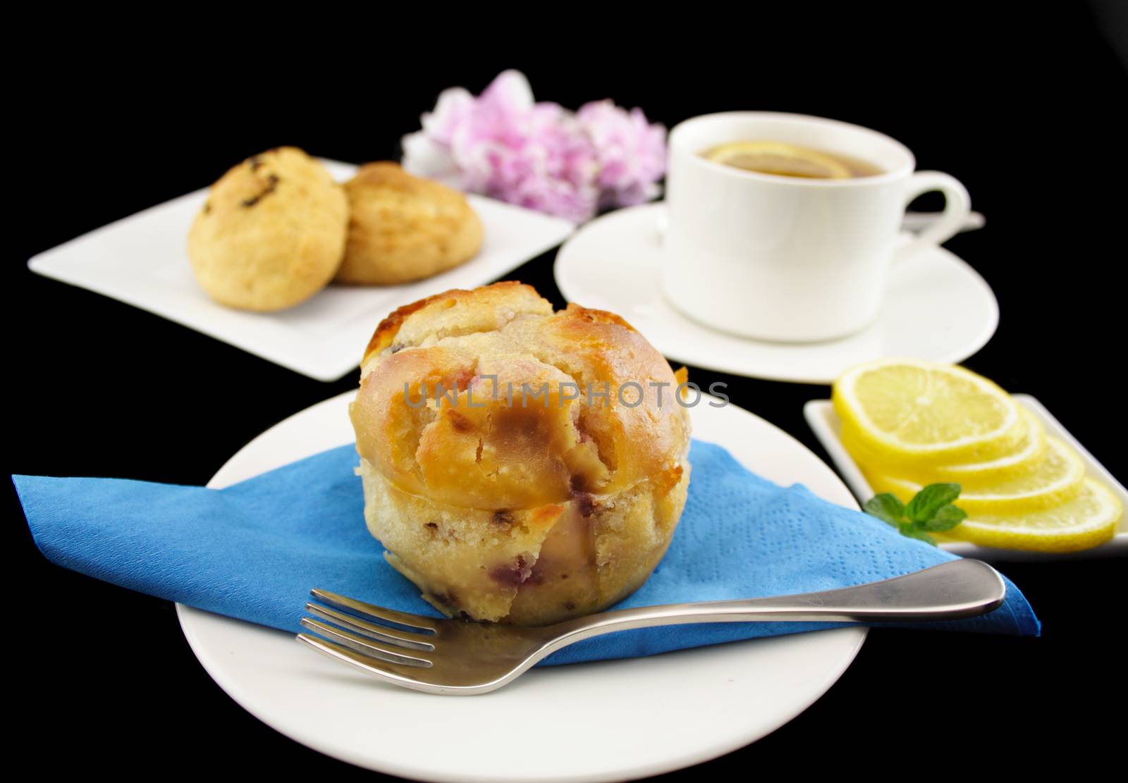 Blueberry muffin and chocolate cookies with with a cup of lemon tea.