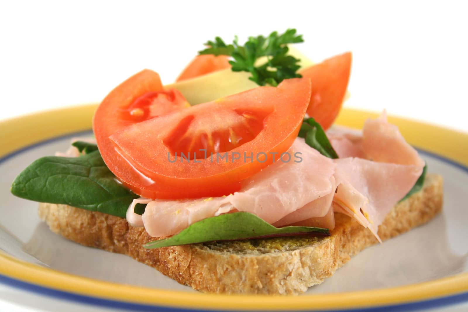 Ham, lettuce, tomato and cheese open sandwich on wholemeal bread.  