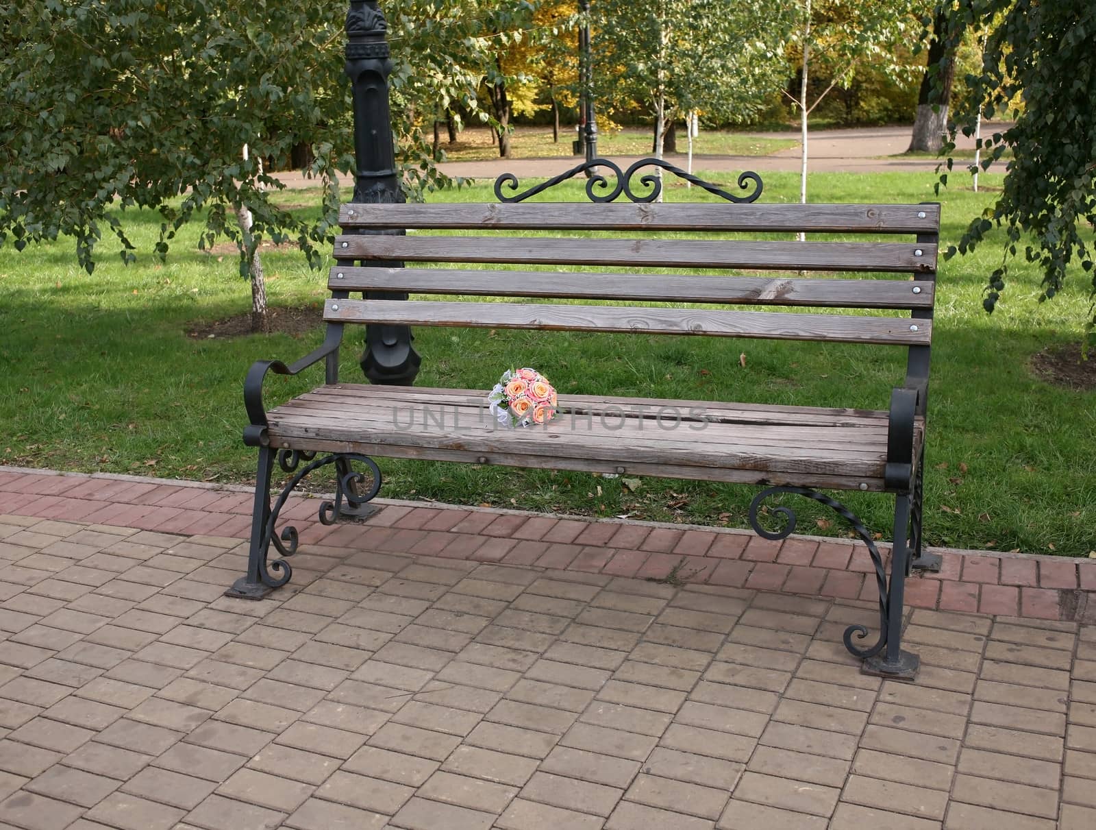 Wedding bouquet of roses on a wooden bench in the park