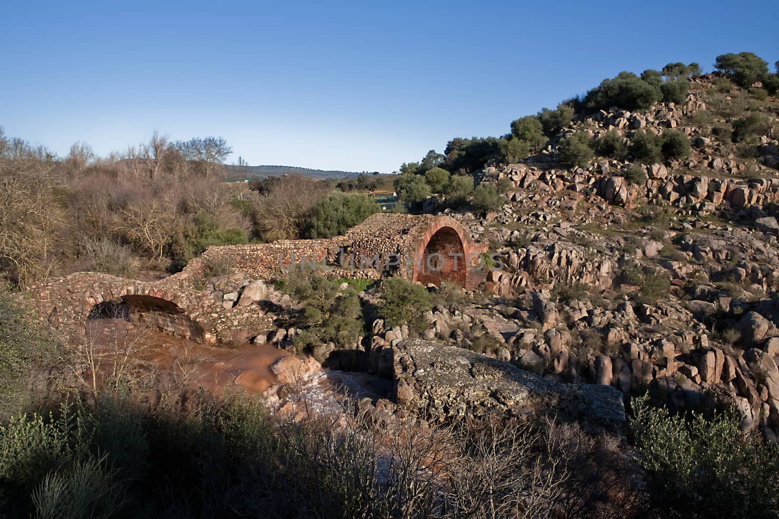 It is a Roman bridge that could belong to the primitive via Herculea, linking the ancient Oretania with the Spanish Levant, 3rd century a. d. C.. Is the landscape a beautiful formation of granitic rocks that are precipitating the River Guarrizas, forming two spectacular waterfalls that save the unevenness caused by the failure of Linares.