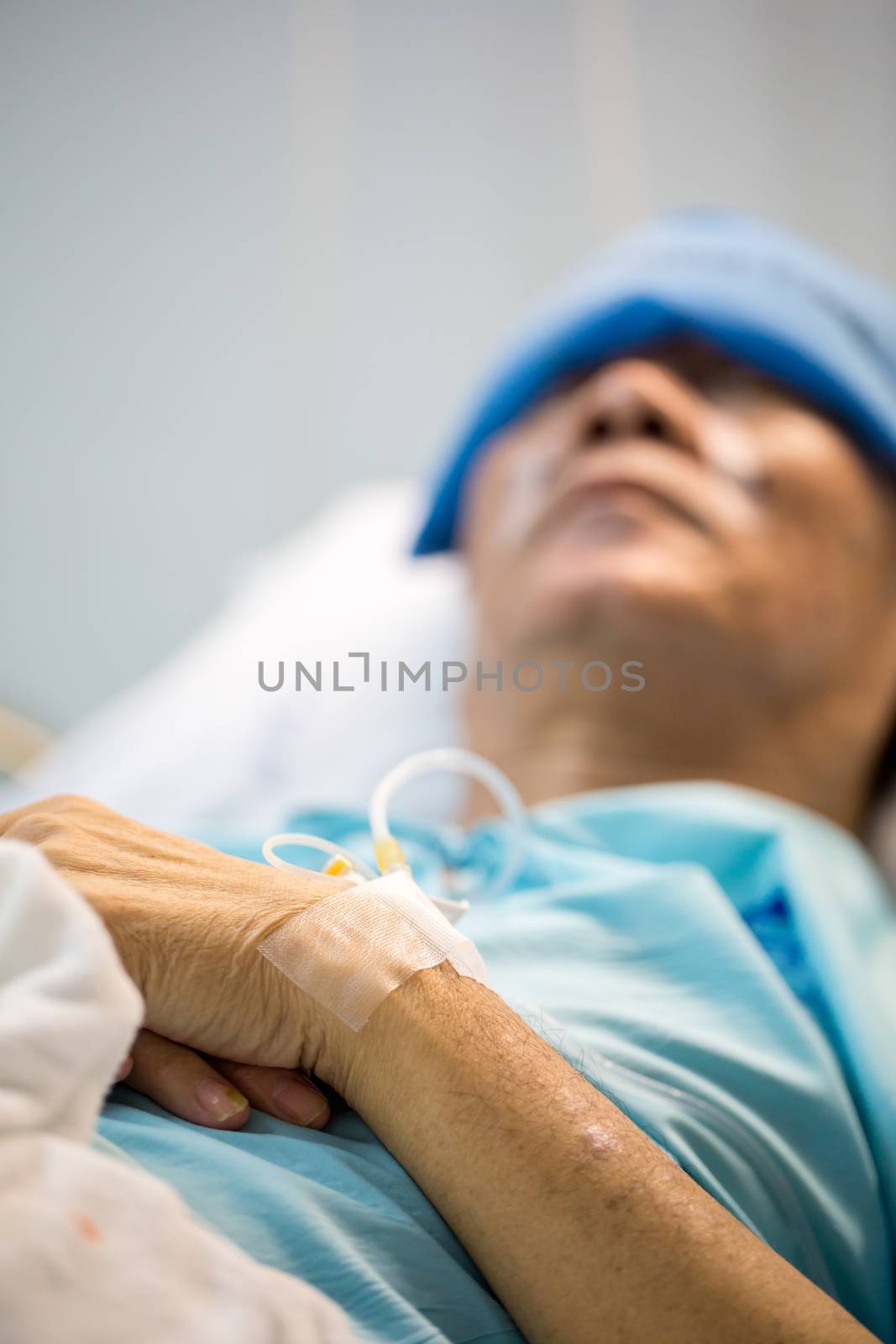 mature senior man Patient sleeping in hospital bed (Selective focus at hand)