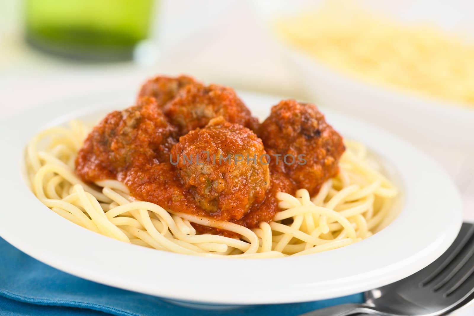 Spanish albondigas (meatballs) in tomato sauce on spaghetti served in bowl (Selective Focus, Focus on the meatball in the front)