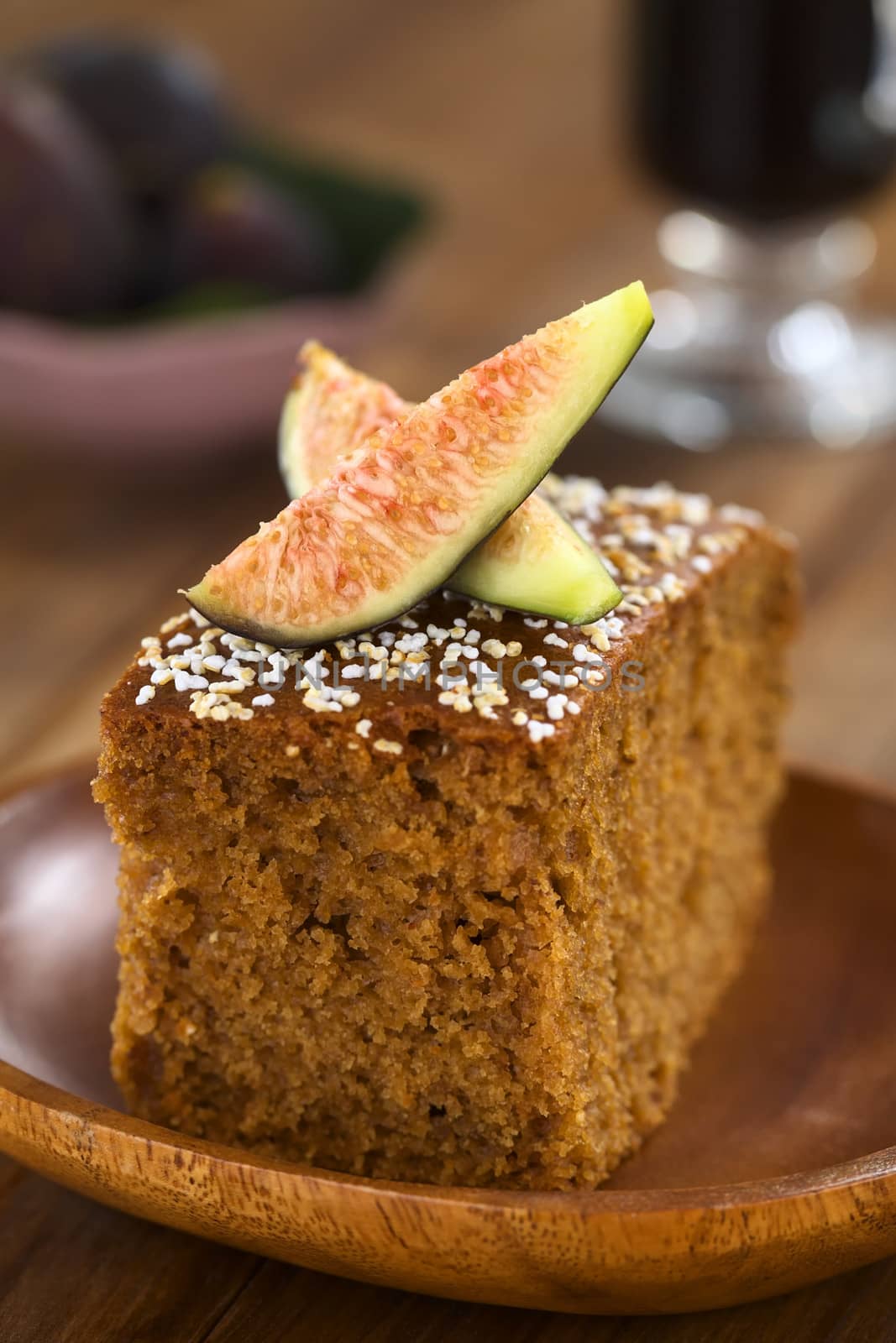 Fresh fig cake with fig wedges on top served on wooden plate (Selective Focus, Focus on the front of the fig wedge)