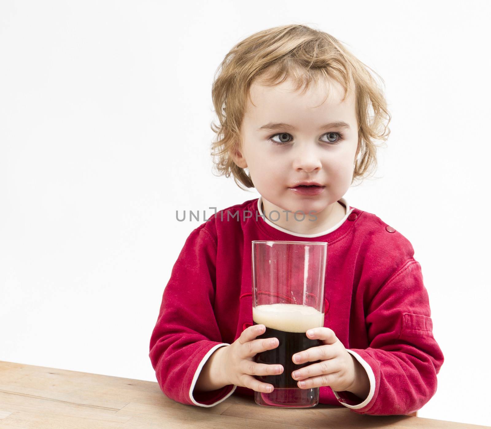 young girl drinking beer in light background. studio shot