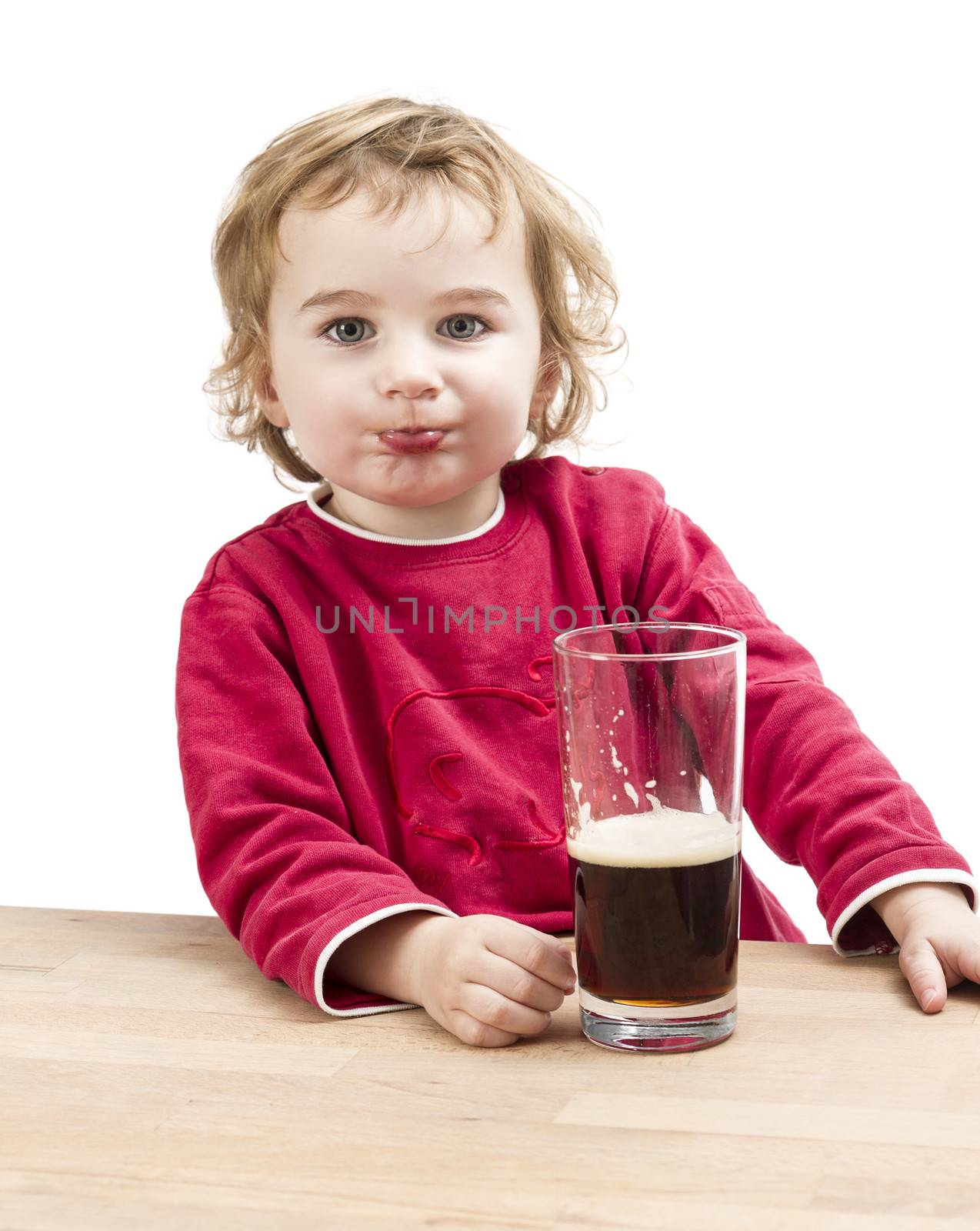 young girl drinking beer in light background. studio shot