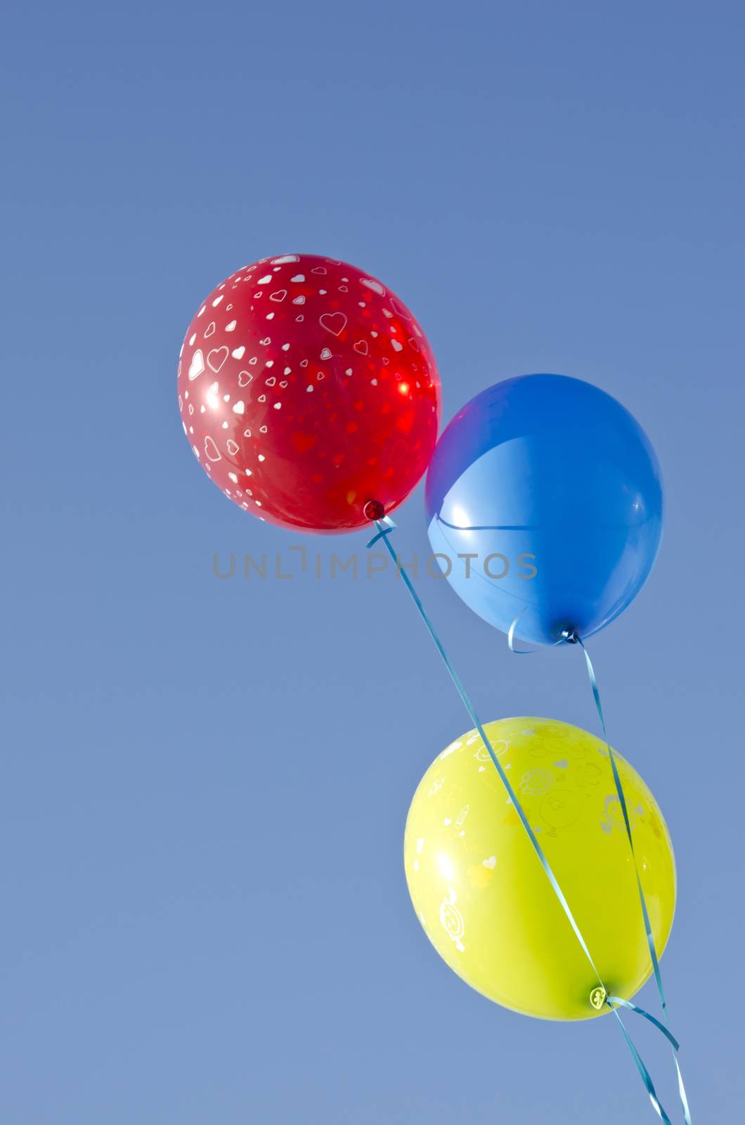 three colorful balloons on blue sky by alis_photo