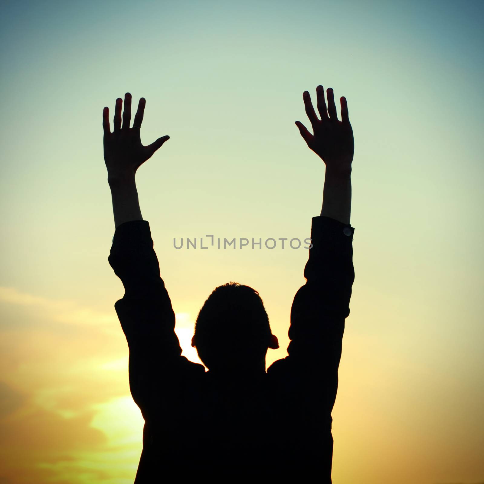Toned photo of Praying Man silhouette on Sunset background