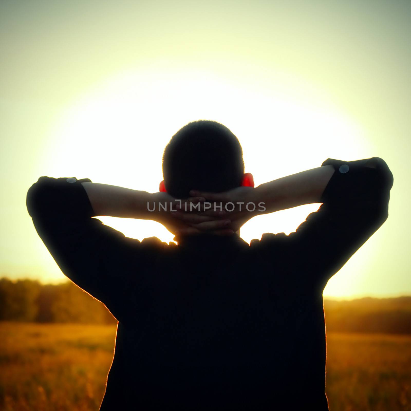 Vintage photo of Young Man silhouette on sunset background