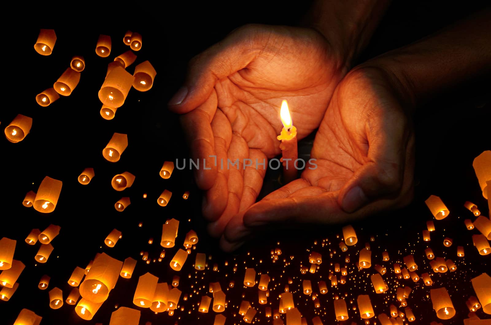 Candle light in hand with Floating lantern in the night sky background, Pray concept