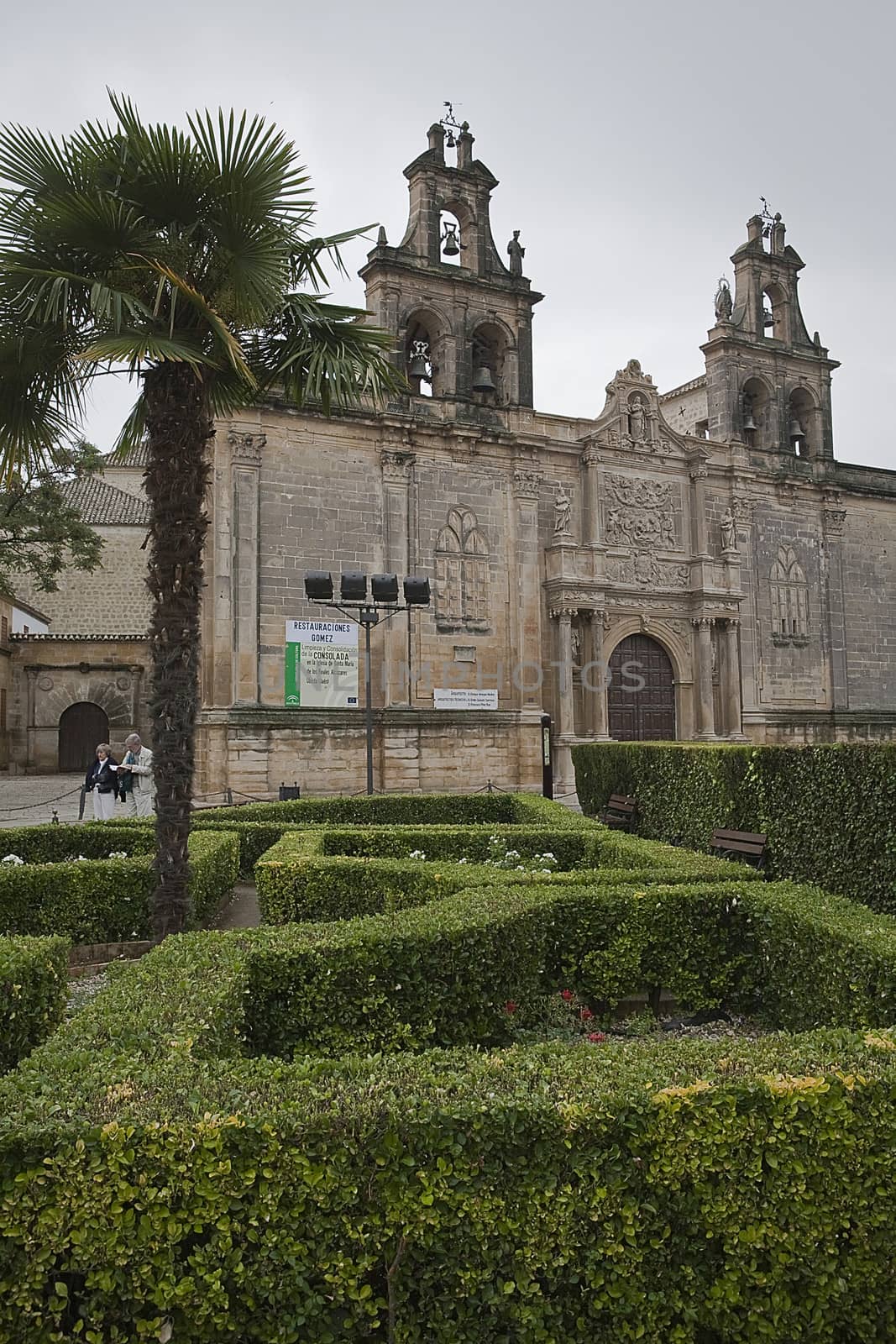 Cloudy day in Church of Santa Maria of the Reales Alcazares from Vazquez de Molina square with hedges in the foreground, Ubeda, Spain
