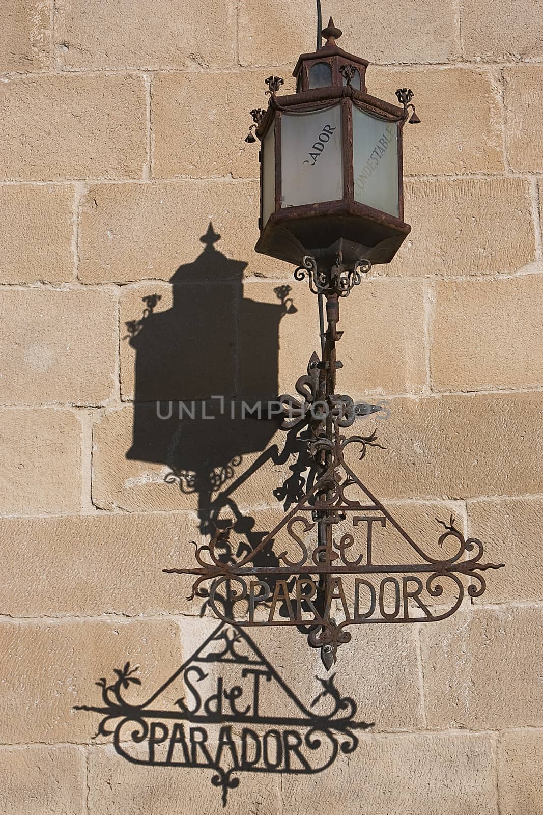 Lamppost on the stone wall of the Hostelry from Ubeda, Jaen province, Spain