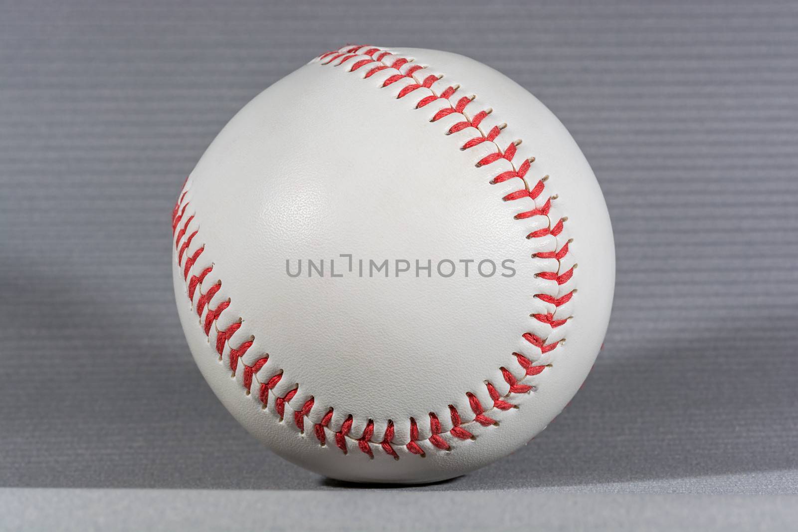 Baseball Ball over gray background, horizontal shot with shallow focus and creative lighting