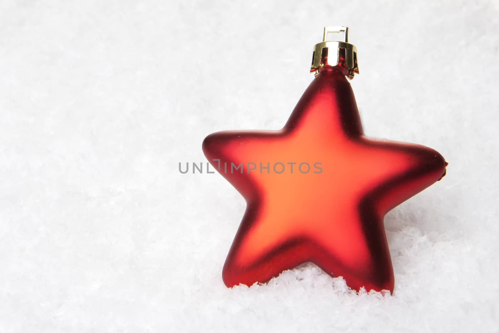 red christmas bauble as christmas star on snow 