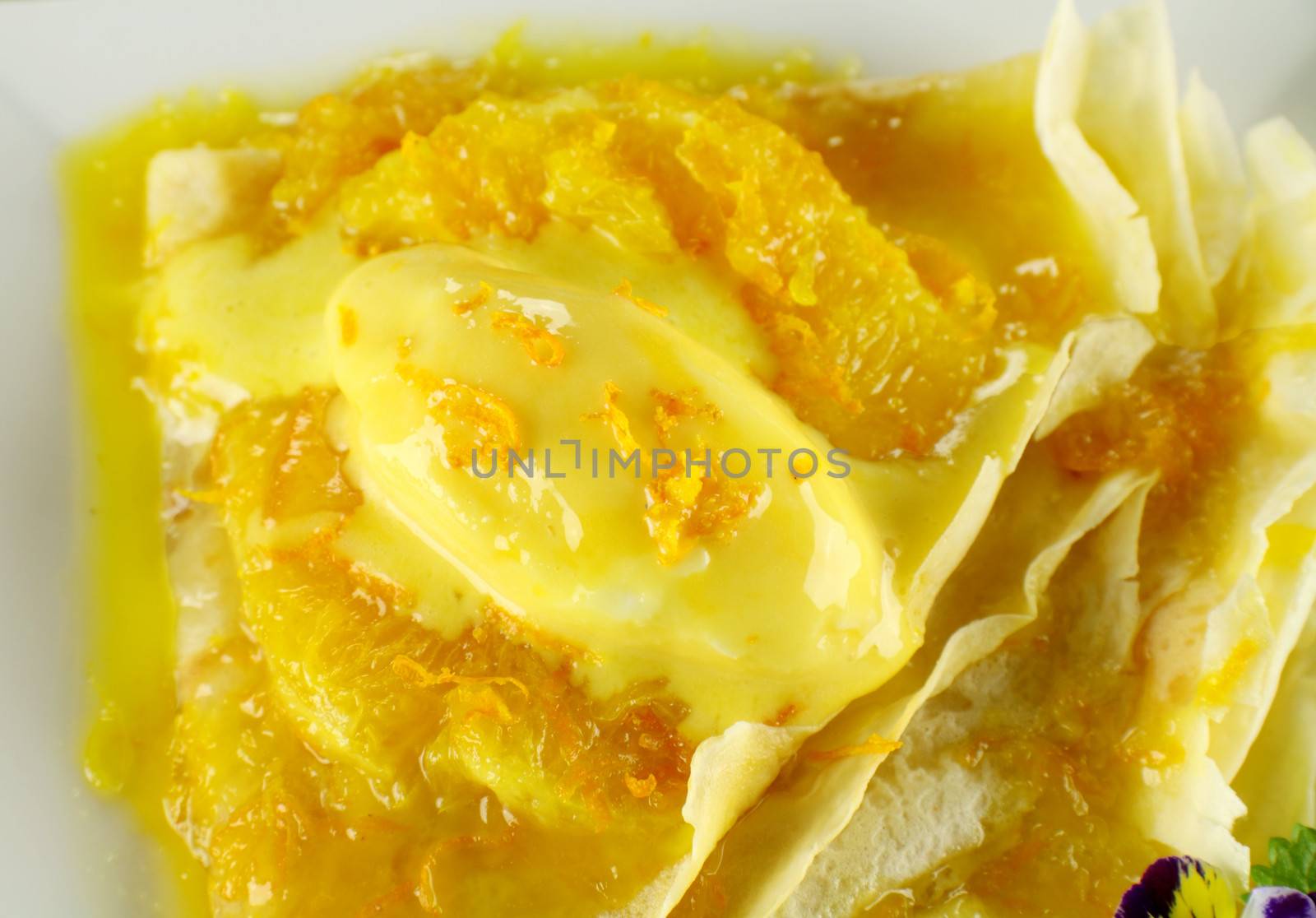Delicious orange crepes with citrus ice cream and custard creme.