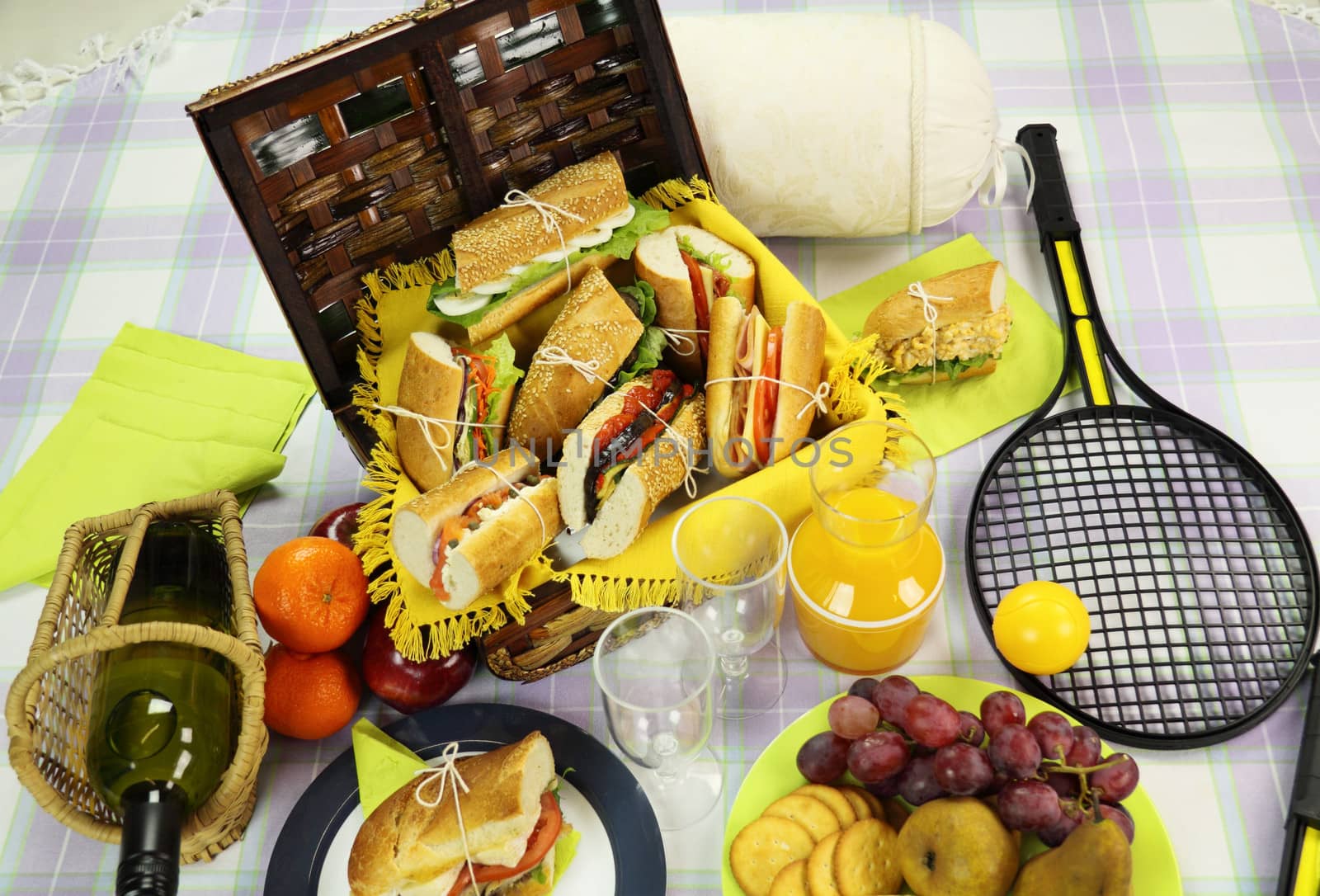 Selection of food for a picnic with a hamper, basket and fruit.