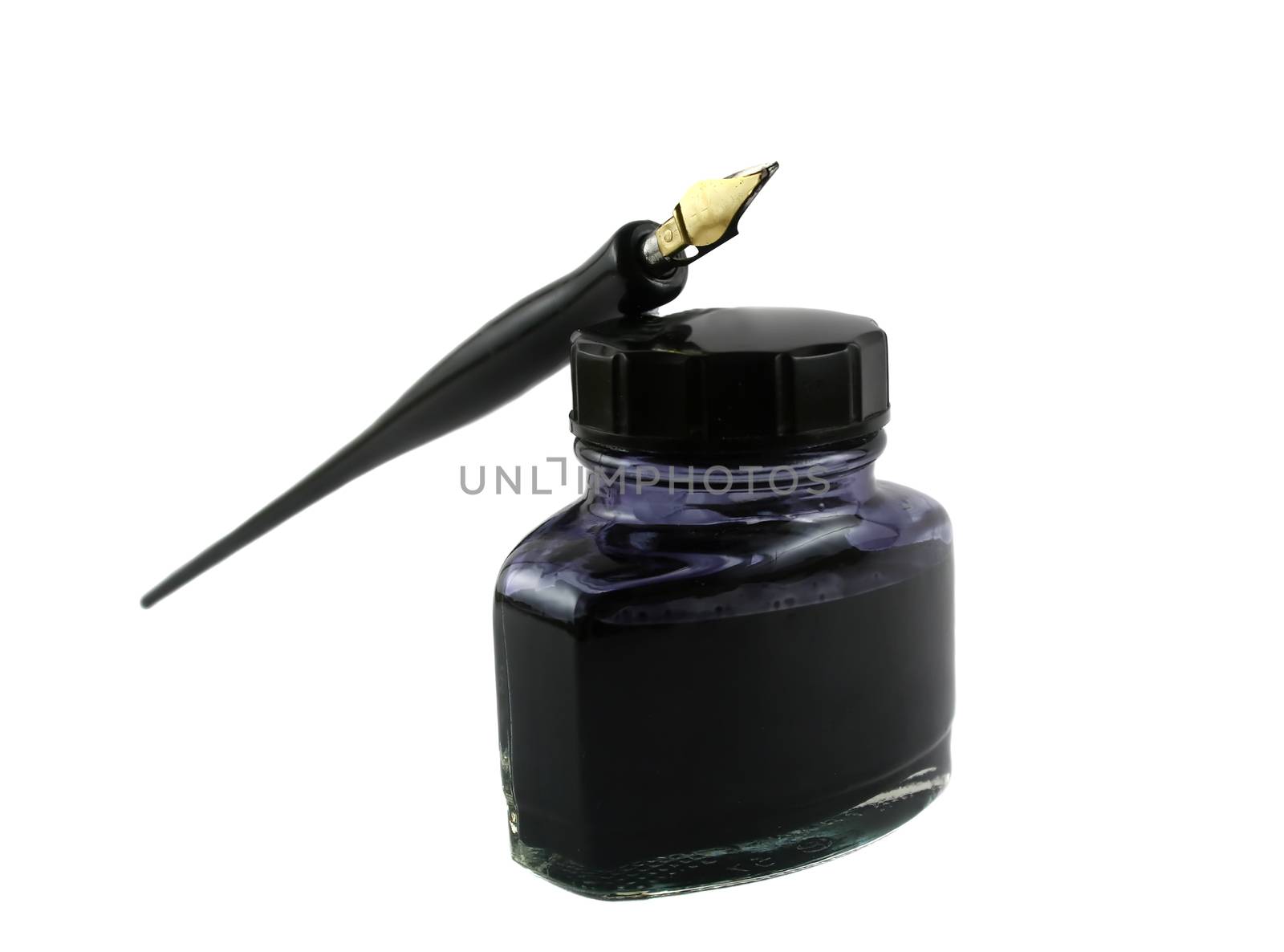 Vintage pen lying on top of a bottle of ink.